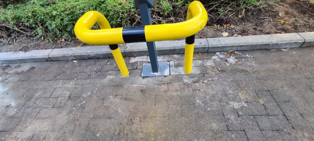 Gele stoeprandbarrière op betegeld trottoir